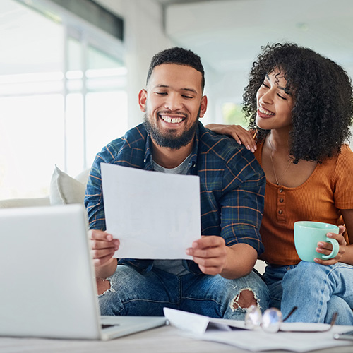 Shot of a happy young couple looking going over their finances at home