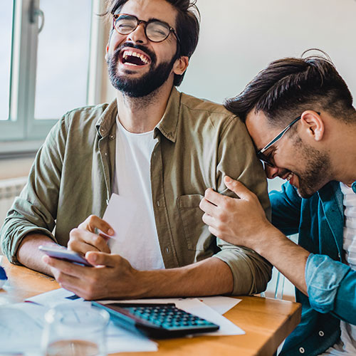 Two young gay freelance workers are at home, they are planning budget